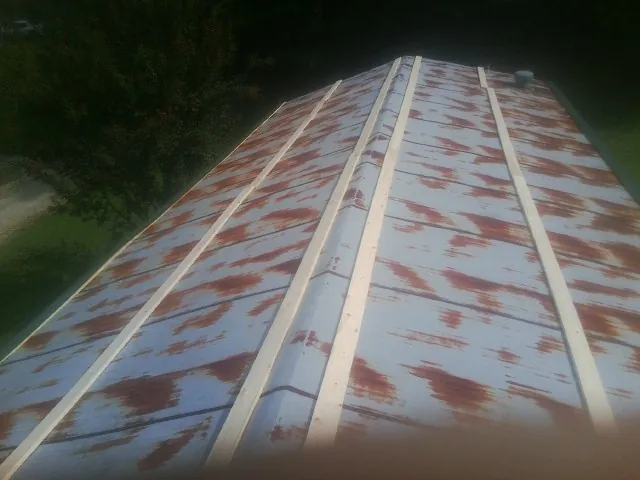 Rusted metal roof panels with new wood purlins before replacement — Storm Damage Roof Repair in Ogdensburg by Roofing Brothers